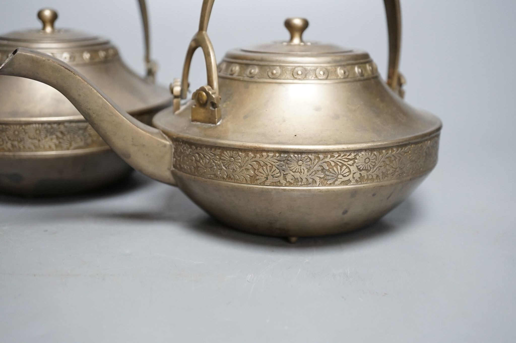 A pair of bronze teapots